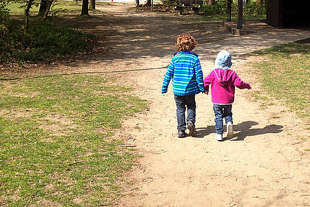 Zwei Kinder Hand in Hand beim Spazierengehen